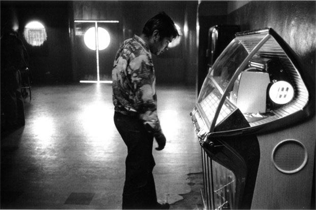 צילום: רוברט פרנק, בחור משחק במכונת הימורים