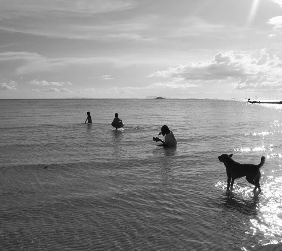 כלב ואנשים בים. צילום של ניר הינדי. מתחילים/ות שחור לבן.